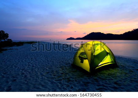 green tent on beach in sunset