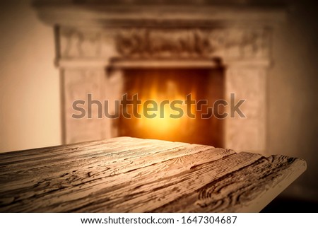 Desk of free space and blurred home interior with fireplace 