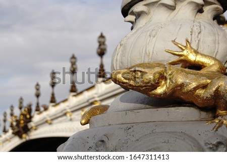 Detail with golden lizard from Alexandre III Bridge, Paris France