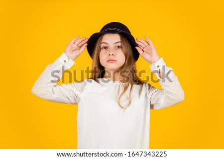   Girl wears a hat yellow background. Happy kid in the hat.  
