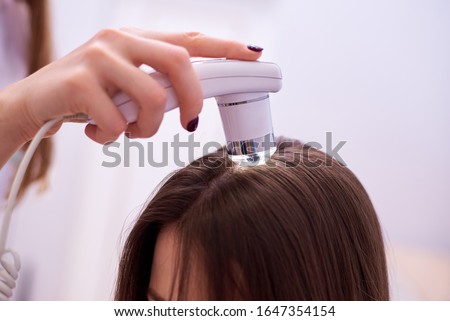 Microscopic examination of the hair and skin of the scalp. Royalty-Free Stock Photo #1647354154