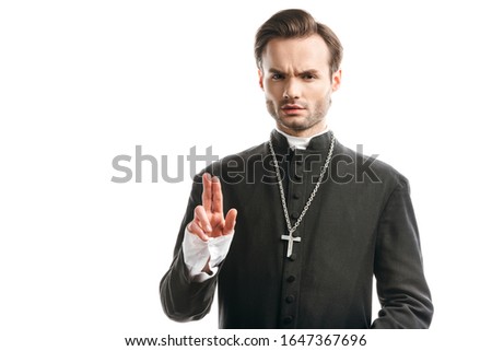 confident, strict catholic priest showing blessing gesture isolated on white