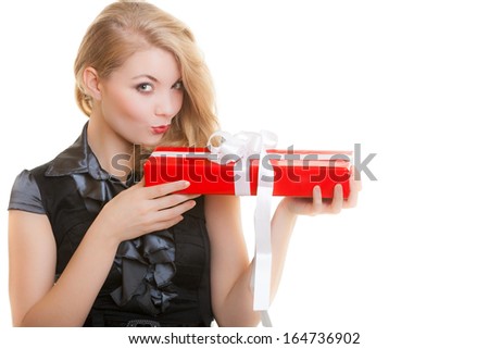 Happy smiling blond girl holding big red christmas gift box with white bow and making funny face. Holiday. Isolated on white. Studio shot.