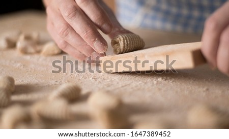 Close up of homemade vegan gnocchi pasta with wholemeal flour on the wooden chopping board with back light morning sunlight bokeh effect, traditional Italian pasta