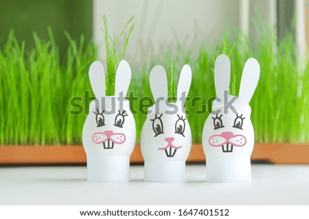 Easter eggs cute rabbit family on the background of green grass. Funny bunny creative decoration. Happy Easter. Easter holiday concept with cute handmade eggs