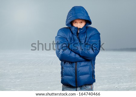 Asian man in blue down-padded coat Royalty-Free Stock Photo #164740466