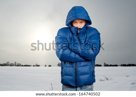 Asian man in blue down-padded coat Royalty-Free Stock Photo #164740502