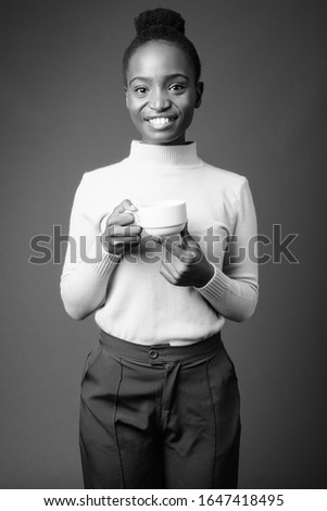 Young beautiful African Zulu businesswoman against gray background
