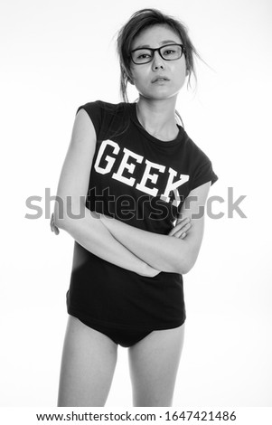 Studio shot of young Asian geek girl against white background