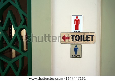 Toilet sign for gents on outside mosque wall.                             