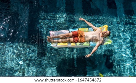 Summer vacation style of handsome man swimming on the pool in the hot sunny day. The top view of man relaxing in pool.Holidays concept.