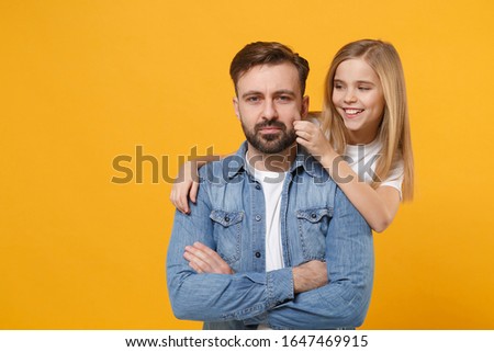 Bearded man in casual clothes have fun with cute child baby girl. Father little kid daughter isolated on yellow wall background. Love family day parenthood childhood concept. Hugging, touching cheek