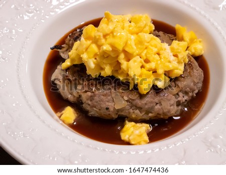 Juicy hamburger with scrambled eggs