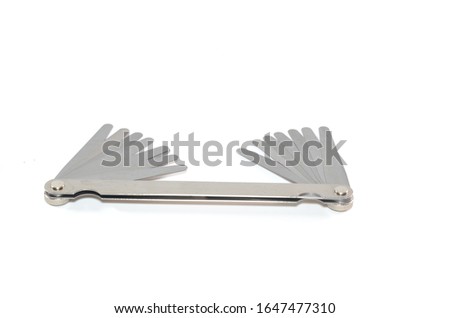 Stainless steel double end feeler gauge on white background Royalty-Free Stock Photo #1647477310