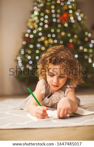 Close up girl writing on a floor on Christmas eve