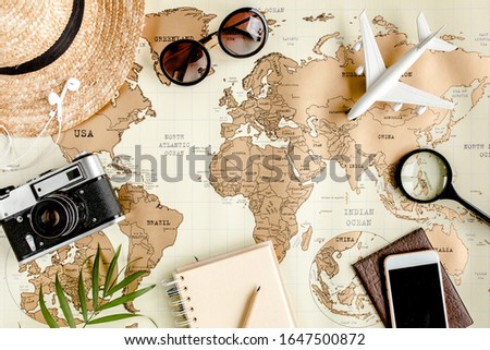 Planning vacation, travel plan, trip vacation using world map along with other travel accessories. Top view, flat lay. Travel, vacation concept.