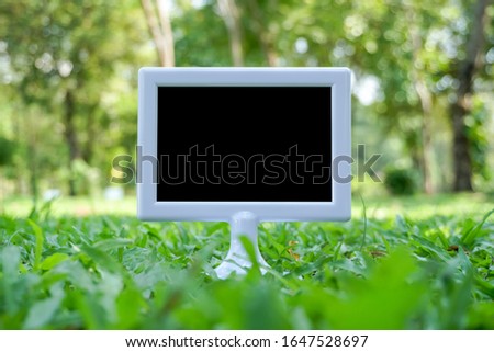 black and white sign board on green grass background