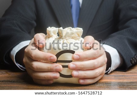 Businessman embraces euro money bags. Financing business project or education. Trade, economics. Corruption. Provision financial loan credit. Bank deposit. Budget, tax collection. Subsidies, savings. Royalty-Free Stock Photo #1647528712