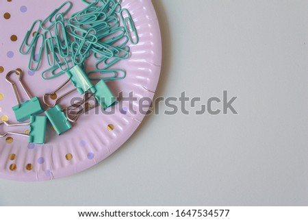 Blue Paper clips on the plate. office supplies with copy space on white background.