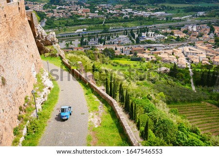 the cutest car in beautiful scenery with green trees and blue sky