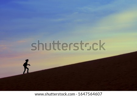 Silhouette of woman rising a hill. Copy space.