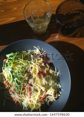 Italiano pasta covered with parmisano and rukkola salad served on tabletop ib cantina