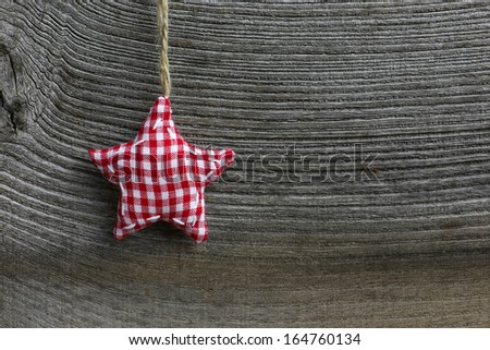 Christmas handmade decoration gingham fabric star over rustic Elm wood background - retro style design, copy space