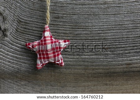 Christmas handmade decoration tartan fabric star over rustic Elm wood background - retro style design, copy space