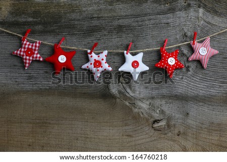 Christmas handmade decoration red and white fabric stars over rustic Elm wood background - retro style design, copy space