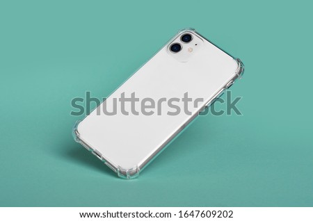 White iPhone 11 in clear silicone case falls down. Smart phone case mock up back view isolated on green background iPhone 12 Royalty-Free Stock Photo #1647609202