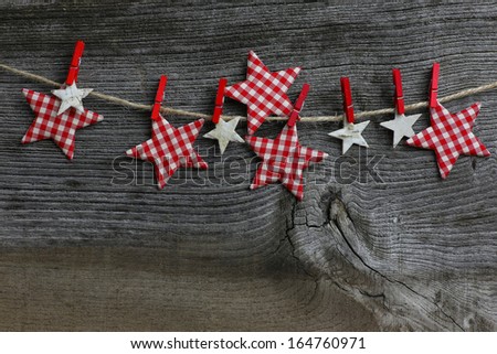 Christmas handmade decoration Birch and gingham fabric stars and red clips over rustic Elm wood background - retro style design, copy space