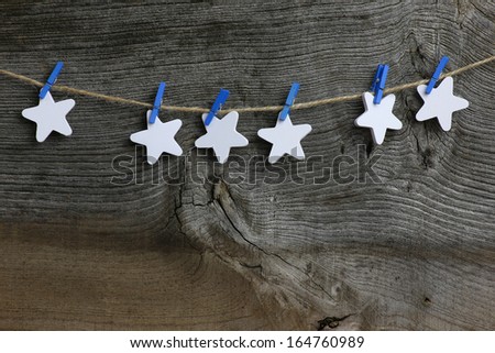 Christmas handmade decoration white wooden stars and blue clips over rustic Elm wood background - retro style design, copy space