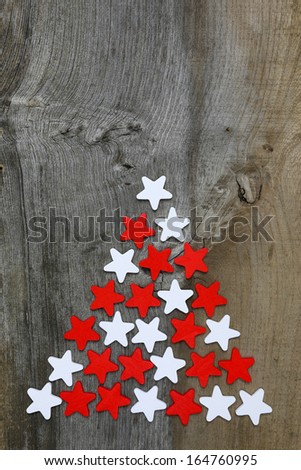 Christmas decoration red and white wooden stars in a shape of pine tree on rustic Elm wood background - retro style design, copy space