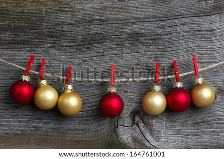Christmas hanging decoration red and gold bulbs with red clips over rustic Elm wood background - retro style design, copy space