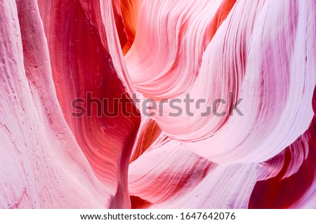 Abstract red silk texture background inside Antelope Canyon, Page, Arizona. Corridors and smoothing hard edges to form characteristic flowing shapes. Formed by the erosion of Navajo Sandstone
