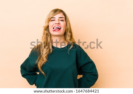 Young blonde caucasian woman funny and friendly sticking out tongue.