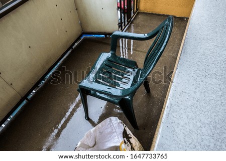 Picture of plastic chair placed in the rain