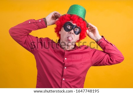 smiling man with black mask, wig and hat, happy carnival concept