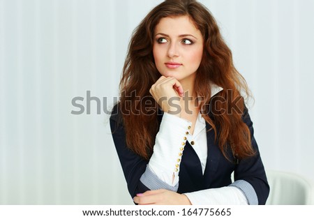 Young beautiful thoughtful businesswoman looking right at copyspace