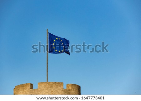 flag of europe waving on castle tower
