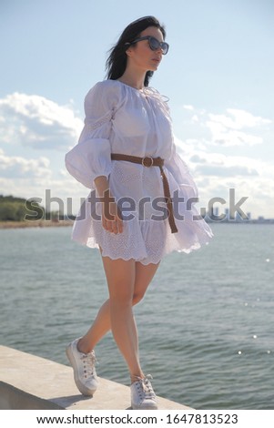 happy girl in a white dress by the sea