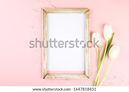 Festive composition on a pink paper background. Photo frame a traditional decoration in the form of a heart for Valentine's Day, Mother's Day, Birthday.