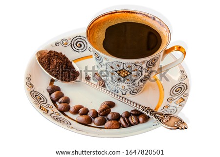 porcelain cup of coffee on a saucer with coffee beans and a spoon of ground coffee on a white background