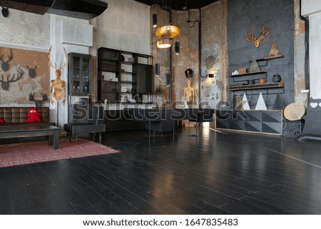 dark design of huge studio apartment in loft style ith big windows and black wooden contemporary furniture with free planing. sitting area. 