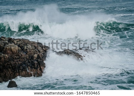 The waves of the ocean hit the rocks with small splashes