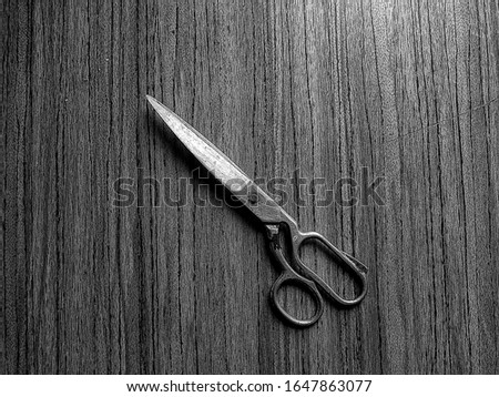 black and white photo of old scissors on a wooden background