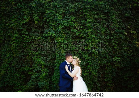 newlyweds kiss and take pictures in the park