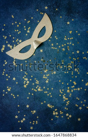 Carnival mask and gold glitter confetti. Top view, Close up on classik blue background.	
