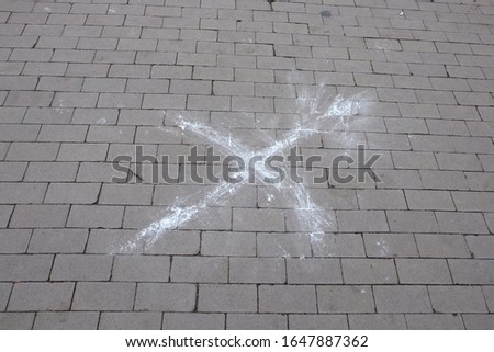 The cross sign on the road or Letter "X" on the ground on the park. It is drawn by paint or chalk. City environment. Top view.