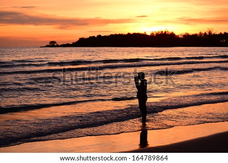 Tropical sunset  and the Photographer takes a good shot on the  beach 